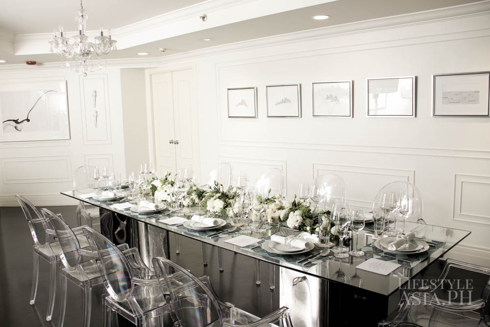 Maureen's long glass table is surrounded by Ghost chairs and dressed in white blooms, crystal stemware and porcelain china