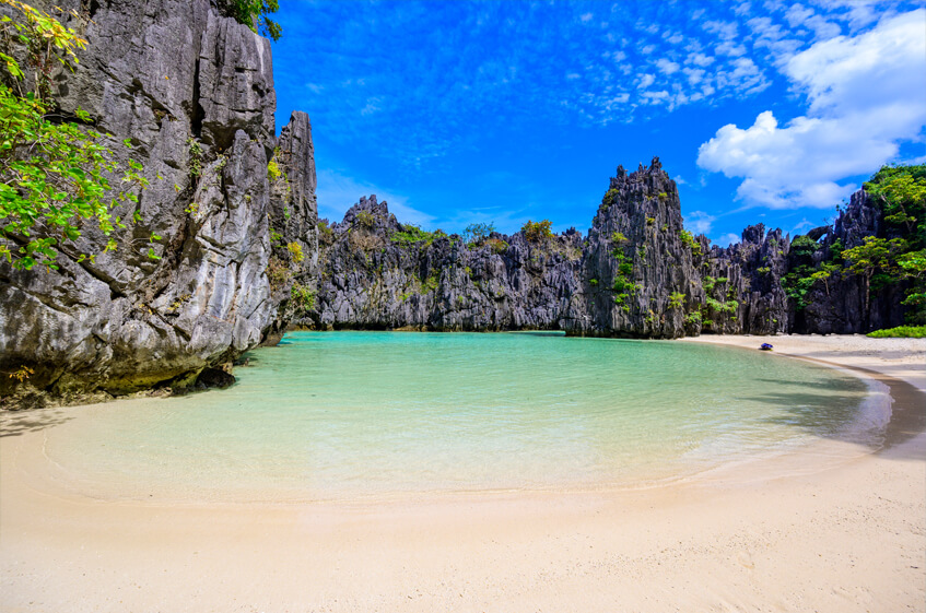 The scenic cove is surrounded by tranquil blue waters and impressive limestone cliffs that protect it from strong winds