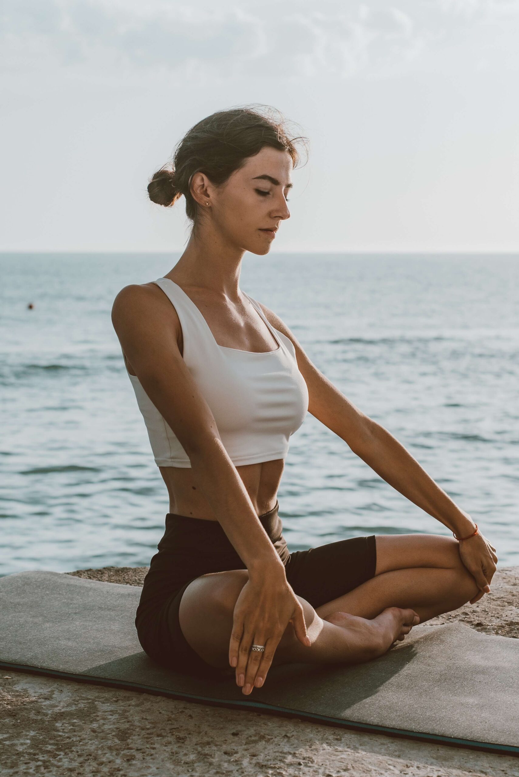 Woman meditating by the beach