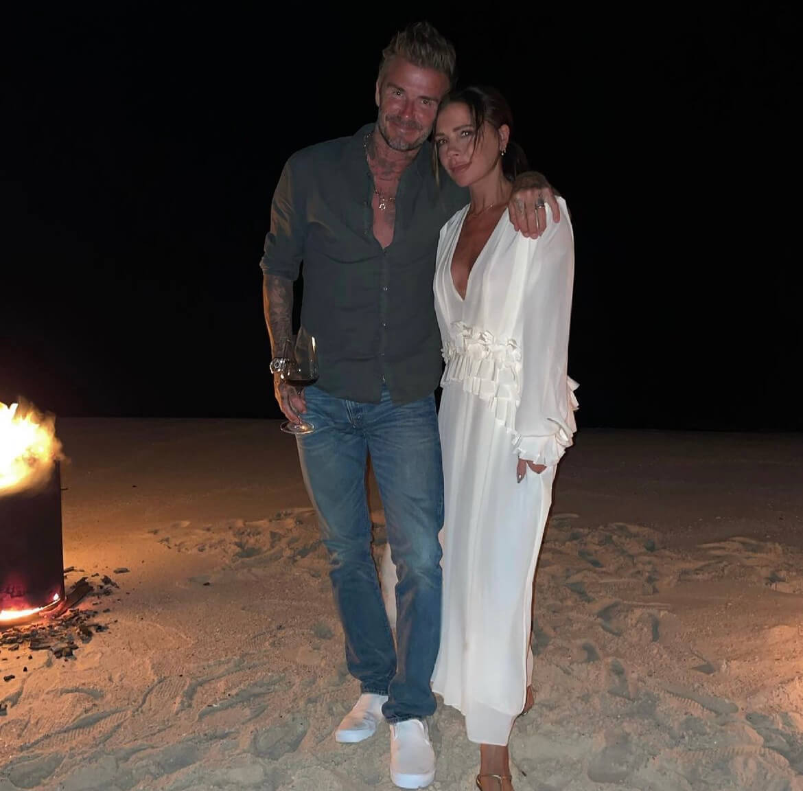David Beckham and Victoria Beckham posing at the beach. 