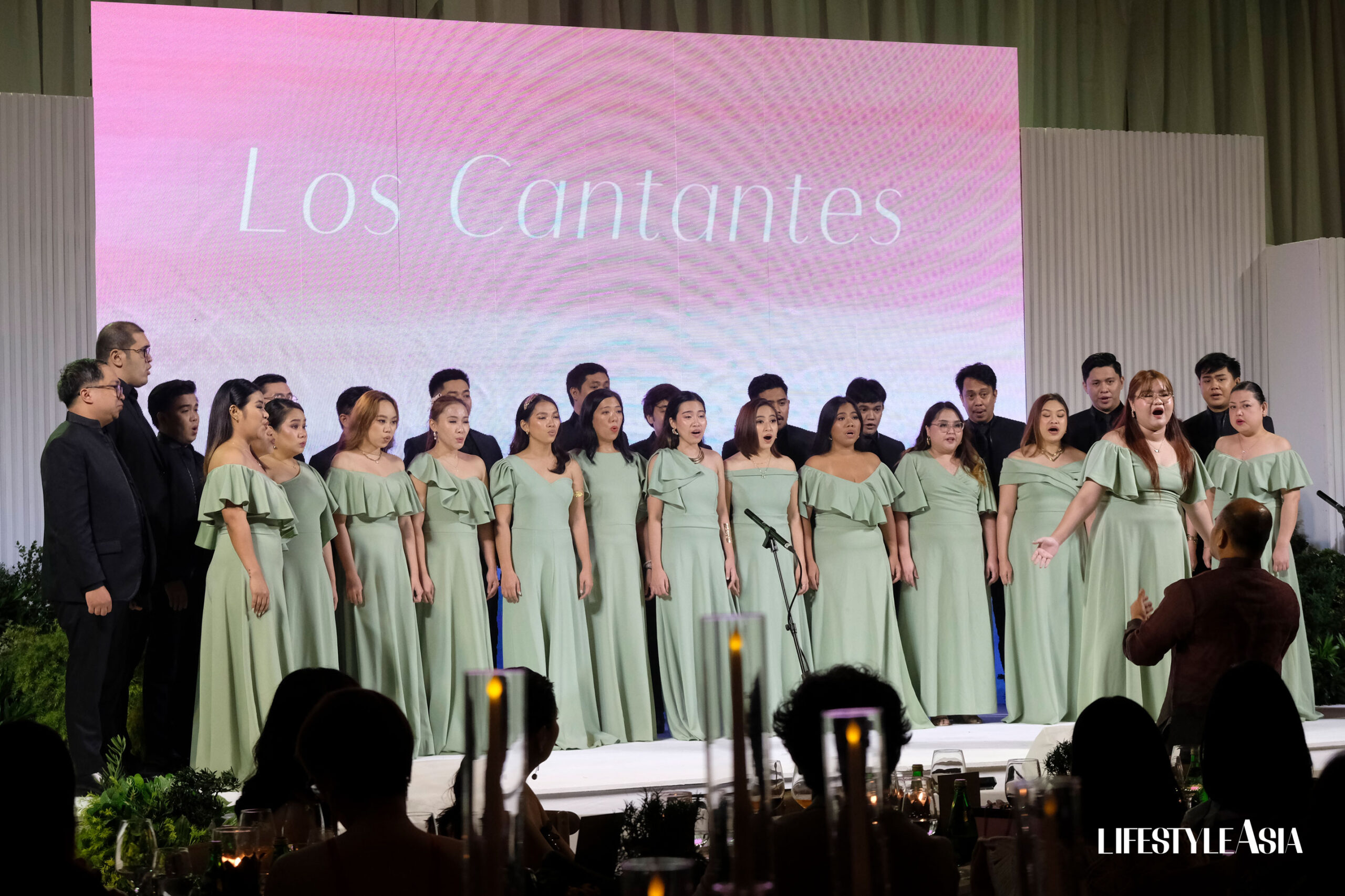 Los Cantantes performs songs on stage