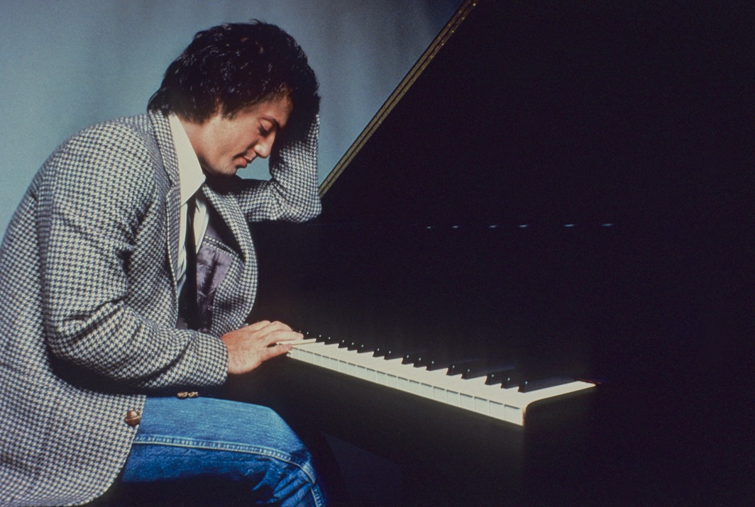 A young Billy Joel by the piano