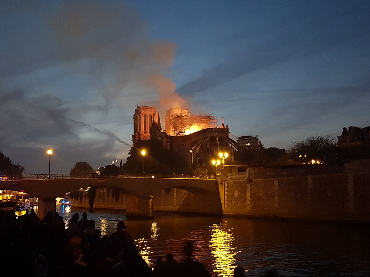 Onlookers watch as the Notre-Dame catches fire on April 15, 2019