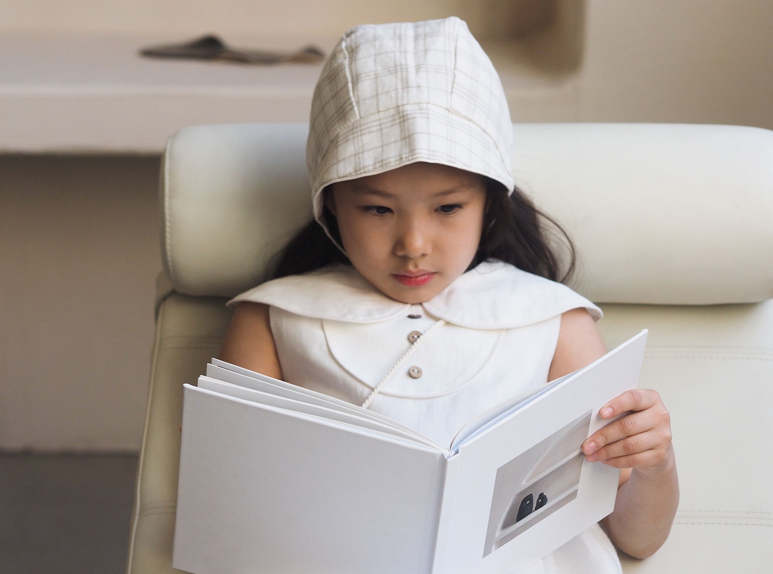 A female child reading a book at home