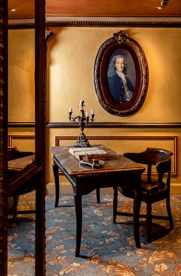 Inside the cafe, which includes a desk that Voltaire himself once worked on (right-most)