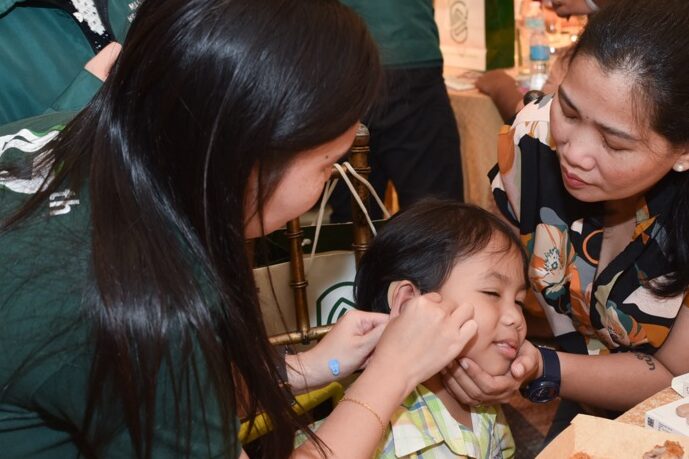 The Manila Hearing Aid team teaching the recipients and their parents on how to use the device