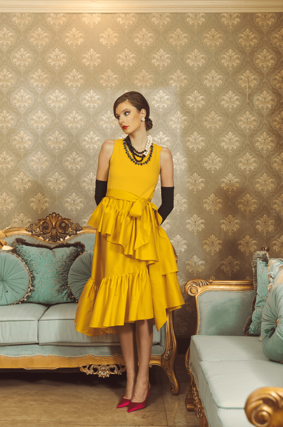 Model wearing yellow marigold ruffle cocktail dress by Rajo Laurel 